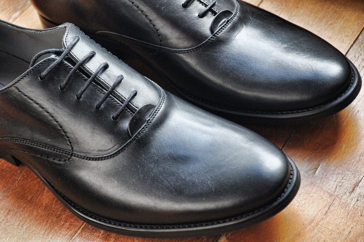 Polished men's formal leather shoes including Oxfords and loafers arranged side by side
