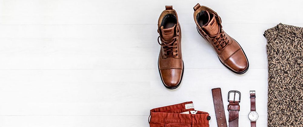 Brown leather boots flat lay with belt and watch